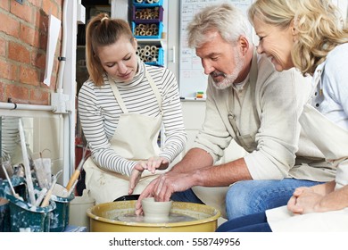 Mature Couple With Teacher In Pottery Class - Powered by Shutterstock