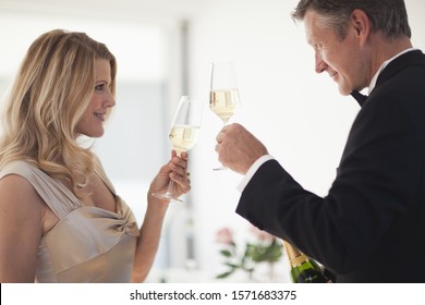 Mature couple toasting with glasses of champagne