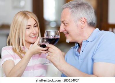 Mature couple toasting wine glasses - Powered by Shutterstock