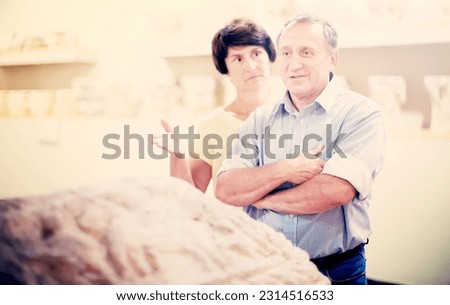 mature couple turists examines basrelief of tomb