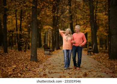 Mature Couple Walking In The Autumn Park