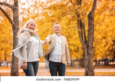 Mature Couple Walking In Park On Autumn Day