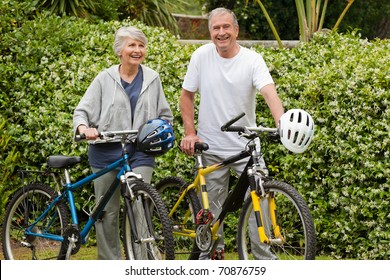 Mature Couple Walking With Their Bikes