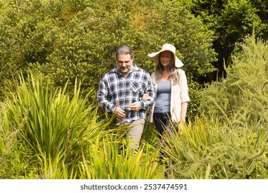 Mature couple walking through lush garden, enjoying peaceful nature together, outdoors. tranquility, relationship, outdoors, serene - Powered by Shutterstock