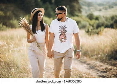 Mature Couple Walking Together In Field