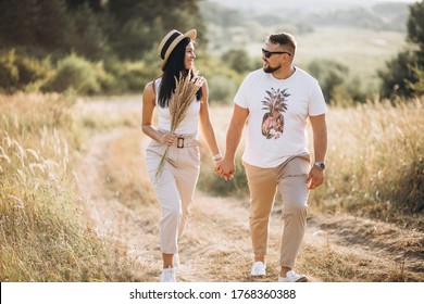 Mature Couple Walking Together In Field