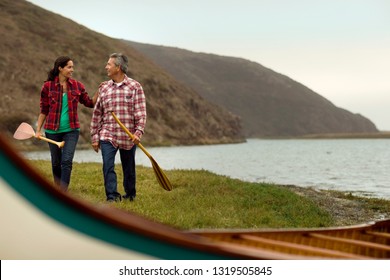 Mature Couple Walking Towards Their Canoe.