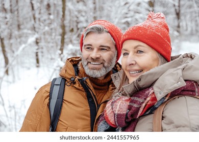 Mature couple in a winter forest feeling happy - Powered by Shutterstock