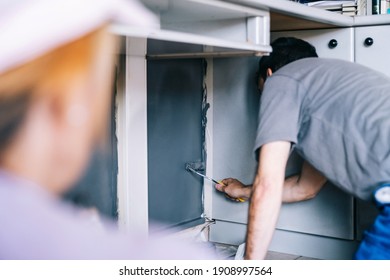 Mature Couple Working On Painting The House. Painters Paint The Wall With A Paintbrush. Paint Wall. DIY Home Decoration Renovation.