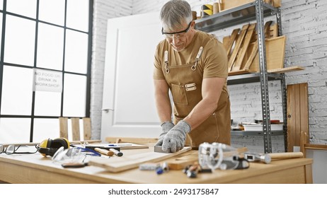 Mature craftsman sanding wood in a bright modern workshop, conveying skilled manual labor. - Powered by Shutterstock