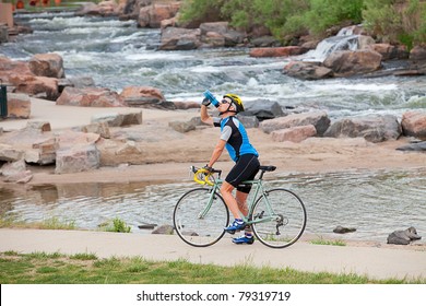 A mature cyclist takes a break by the river - Powered by Shutterstock