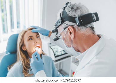 Mature doctor checking woman throat with medical stick - Powered by Shutterstock