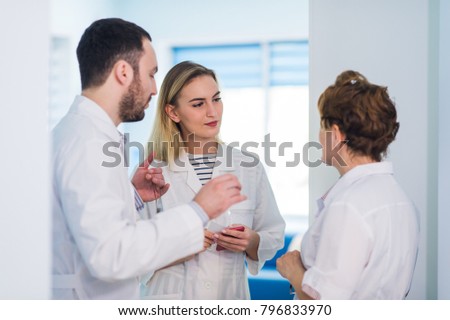 Mature doctor discussing with nurses in a hallway hospital. Doctor discussing patient case status with his medical staff after operation.