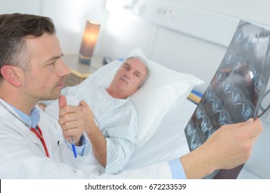 mature doctor examinating patients xray at the hospital - Shutterstock ID 672233539