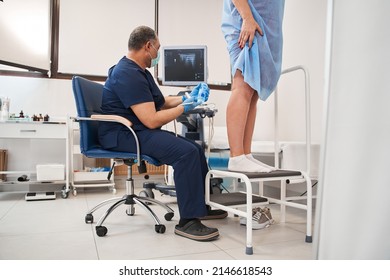 Mature Doctor Examining Woman Leg With Special Gel During The Procedure At The Clinic