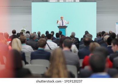 Erwachsener Arzt, der auf einer Konferenz vor Publikum eine Rede auf einer Bühne hält