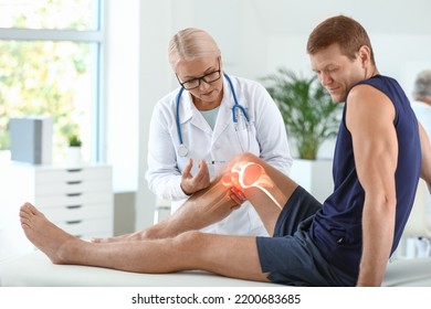 Mature doctor giving sporty man with joint pain injection in clinic - Shutterstock ID 2200683685