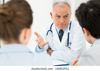 Mature Doctor Involved In Serious Discussion With His Patients