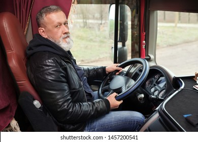 Mature Driver Sitting In Cab Of Modern Truck