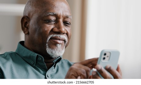 Mature elderly old African 60s biracial man using phone American businessman male grandfather free wi-fi chatting mobile app at home browsing net texting message in smartphone internet technology - Powered by Shutterstock