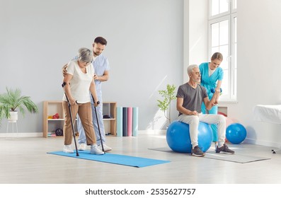 Mature elderly people doing exercises with the help of fitness trainers or health care workers in rehabilitation clinic. Senior retired man and woman exercising for health in gym with physiotherapist - Powered by Shutterstock