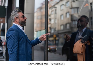 A Mature Elegant Business Man Choosing A Suit In Mall Or Clothing Store While Looking At The Shop Window.