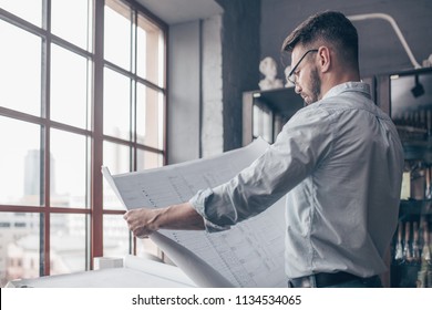 Mature Engineer With A Drawing Indoors