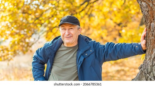 Mature European Man With A Good Mood, Outdoor Portrait At Autumn Park . The Concept Of Life After 50 Years	