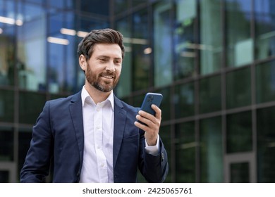 Mature executive in formal attire smiling while checking his phone. Professional urban setting reflects success and connectivity. - Powered by Shutterstock