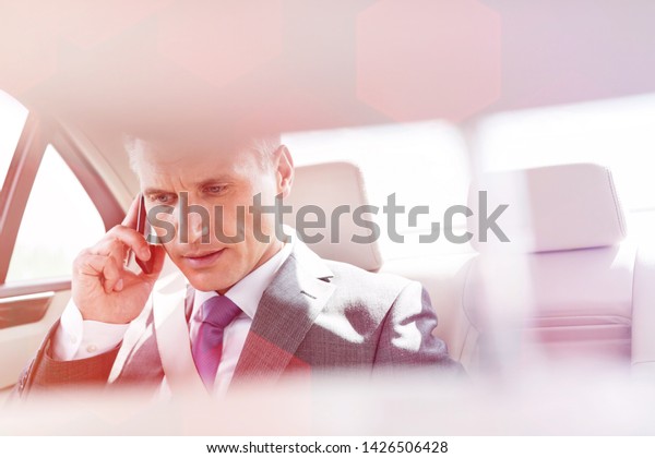 Mature executive\
talking on smartphone in\
car