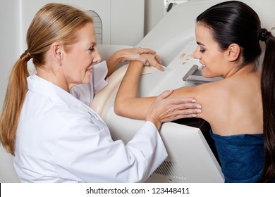 Mature female doctor assisting young patient during mammography