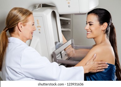 Mature female doctor assisting young patient during mammogram x-ray test