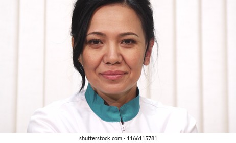 Mature Female Doctor Holding Pink Ribbong Cancer Awareness Symbol In Her Hands