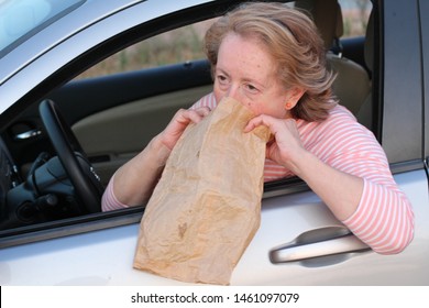 Mature Female Driver Vomiting In Paper Bag