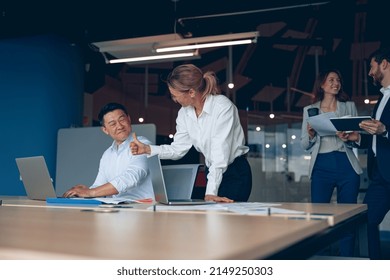 Mature Female Employee Discussing Online Project, Showing Presentation To Skilled Team Leader.