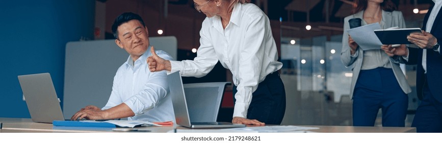 Mature Female Employee Discussing Online Project, Showing Presentation To Skilled Team Leader.