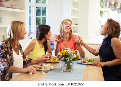 Mature Female Friends Sitting Around Table At Dinner Party