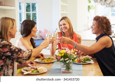 Mature Female Friends Sitting Around Table At Dinner Party