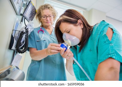 Mature Female Nurse Woman In Active Labor With Nitrous Oxide Mask.