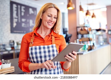 Mature Female Owner Of Coffee Shop Or Restaurant Using Digital Tablet - Shutterstock ID 2185088497