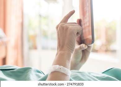 Mature Female Patient Used Tablet On Bed In Hospital