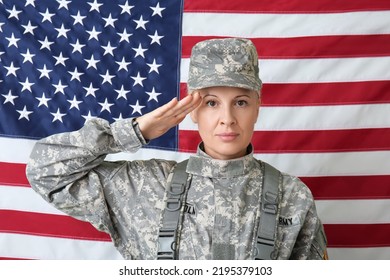 Mature Female Soldier Saluting Against USA Flag