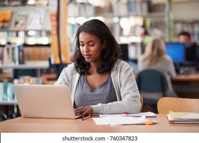 Mature Female Student Working On Laptop In College Library