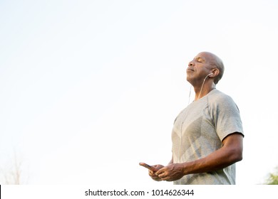 Mature fit African American man texting and listening to music. - Powered by Shutterstock