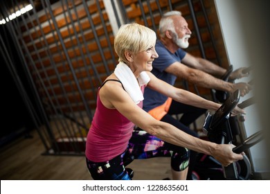 Mature Fit Couple Exercising In Gym To Stay Healthy