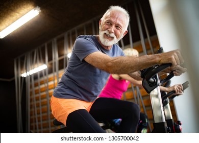 Mature fit couple exercising in gym to stay healthy - Powered by Shutterstock