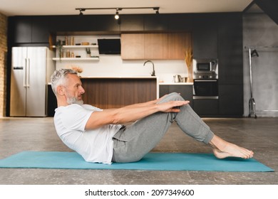 Mature fit middle-aged sporty man in fitness clothes doing exercises at home on mat, stretching, slimming, doing workout on lockdown - Powered by Shutterstock