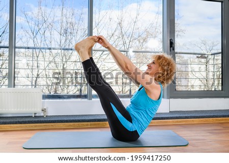 Mature fit woman warming up body indoors