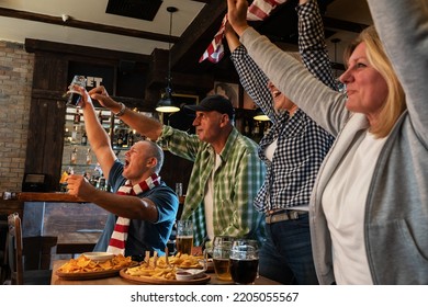 	
Mature Football And Soccer Fans Drinking Beer At The Pub And Celebrating Scores.	
