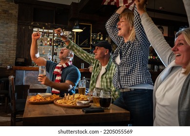 	
Mature Football And Soccer Fans Drinking Beer At The Pub And Celebrating Scores.	
